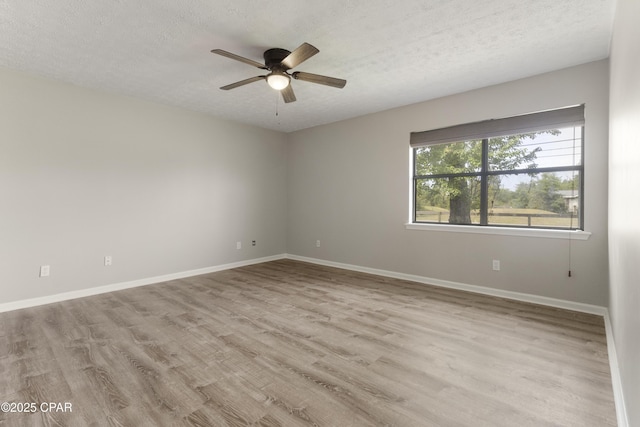 unfurnished room with a textured ceiling, wood finished floors, ceiling fan, and baseboards