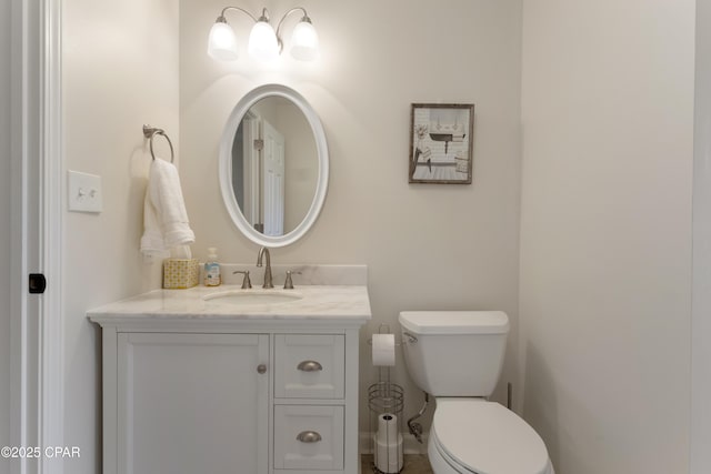half bathroom featuring vanity and toilet