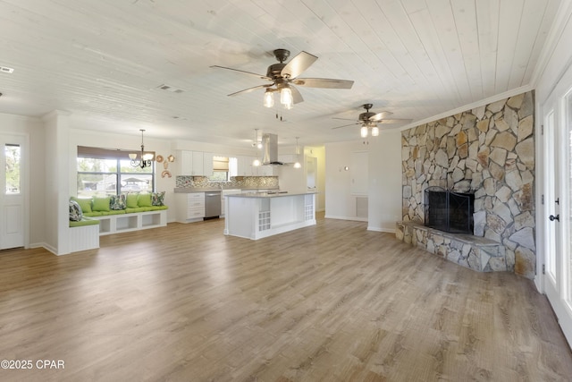 unfurnished living room featuring ornamental molding, ceiling fan with notable chandelier, a stone fireplace, and wood ceiling