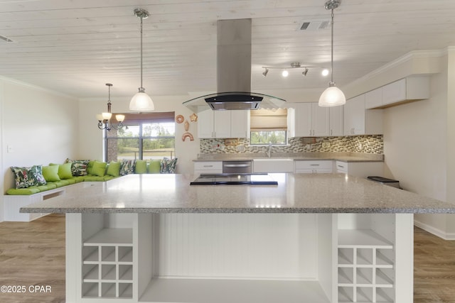 kitchen featuring a spacious island, island exhaust hood, light wood-style flooring, and white cabinetry