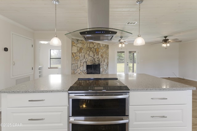 kitchen with visible vents, island range hood, range with two ovens, and open floor plan