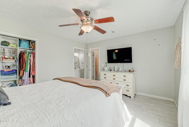 bedroom featuring visible vents, a closet, baseboards, ensuite bathroom, and ceiling fan