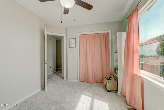 unfurnished bedroom with a closet, a ceiling fan, and carpet flooring
