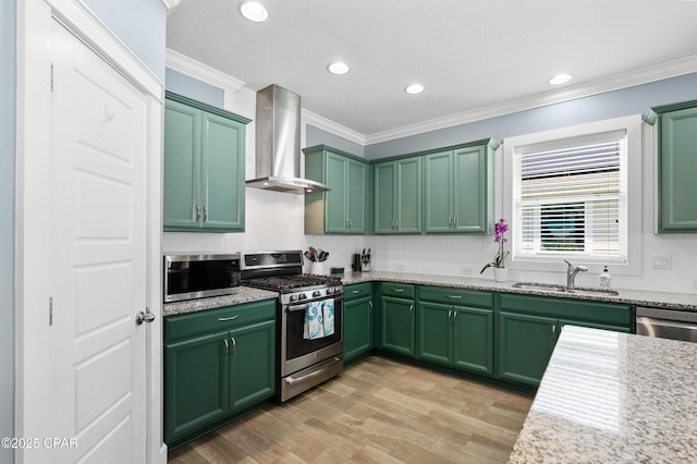 kitchen featuring a sink, green cabinets, stainless steel appliances, and wall chimney exhaust hood