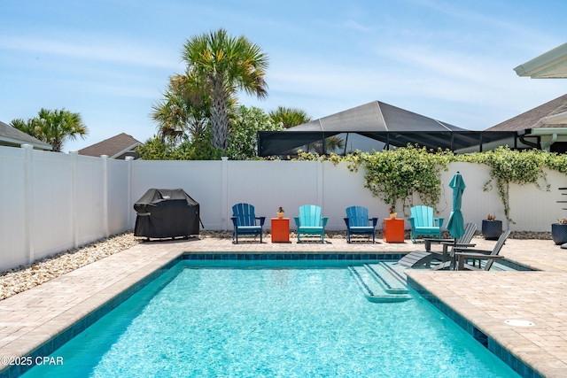 view of swimming pool with a fenced backyard, a fenced in pool, a patio, and area for grilling