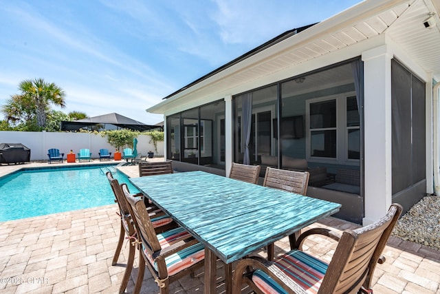 view of swimming pool featuring area for grilling, a sunroom, a fenced in pool, a fenced backyard, and a patio