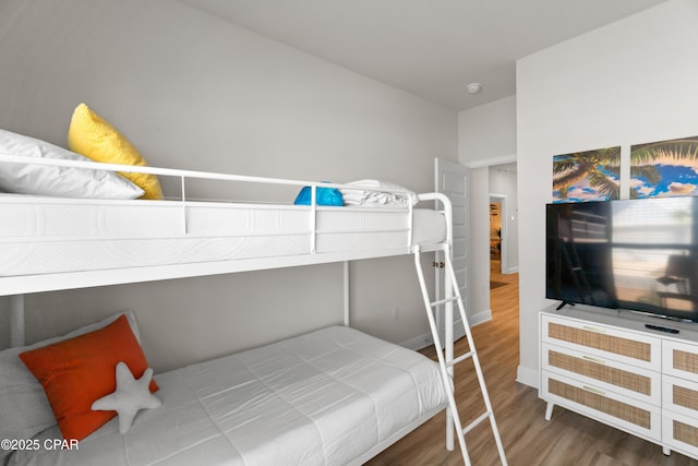 bedroom with baseboards and wood finished floors