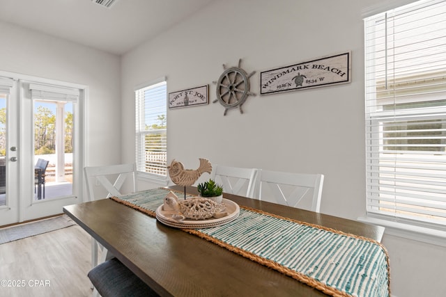 dining space with light wood-style floors and french doors