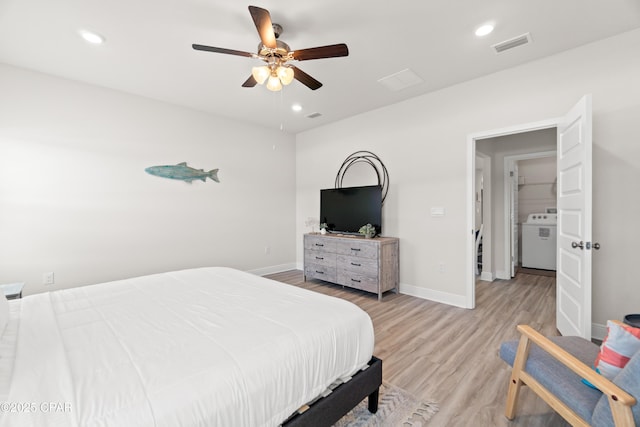 bedroom with light wood-type flooring, baseboards, washer / clothes dryer, and visible vents