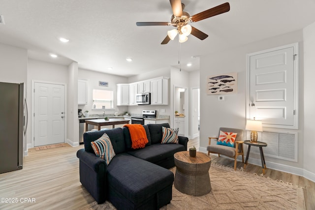 living area with visible vents, baseboards, ceiling fan, light wood-type flooring, and recessed lighting