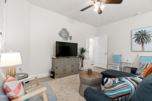 living room with baseboards, a ceiling fan, light wood-style flooring, and visible vents