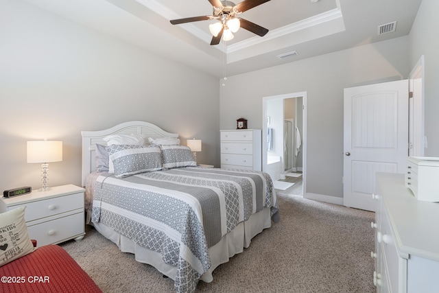 bedroom with light colored carpet, ornamental molding, a tray ceiling, and visible vents