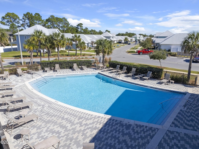 pool featuring a residential view, a patio, and fence