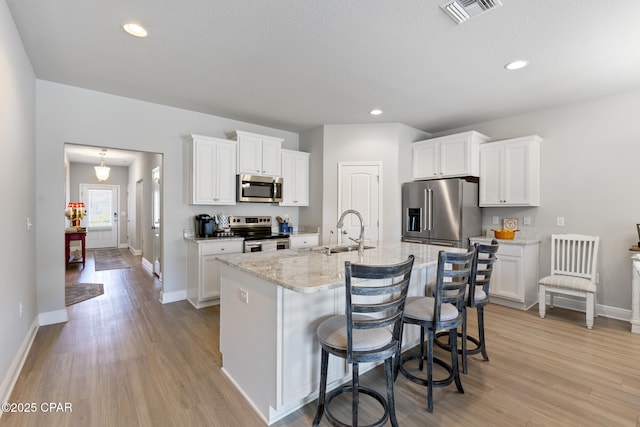 kitchen with visible vents, a sink, light wood-style floors, and appliances with stainless steel finishes