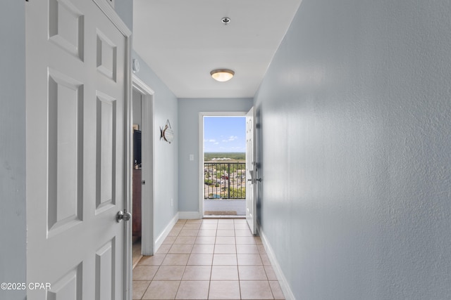 entryway with baseboards and light tile patterned floors