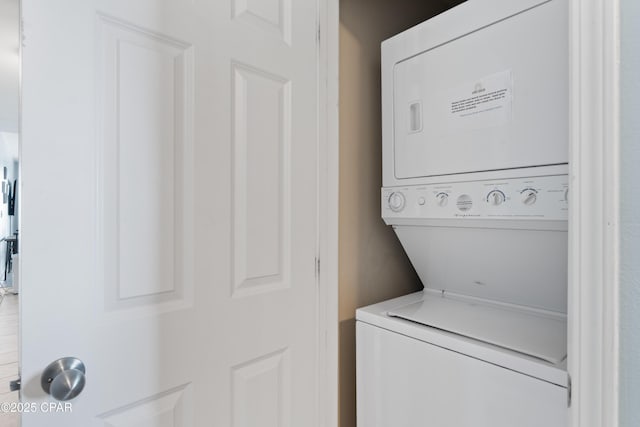 laundry area featuring stacked washer / dryer and laundry area