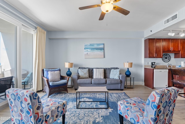 living room with baseboards, light wood-style flooring, visible vents, and ceiling fan