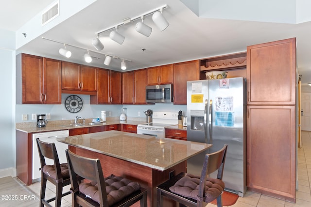 kitchen with open shelves, a breakfast bar area, stainless steel appliances, light stone countertops, and visible vents