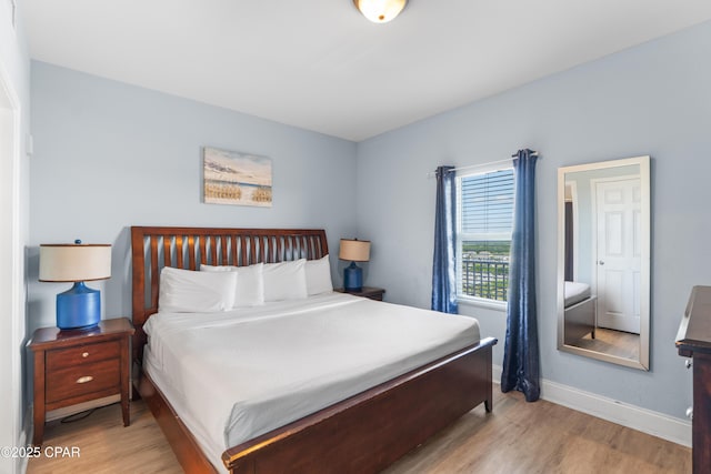 bedroom with light wood-style floors and baseboards