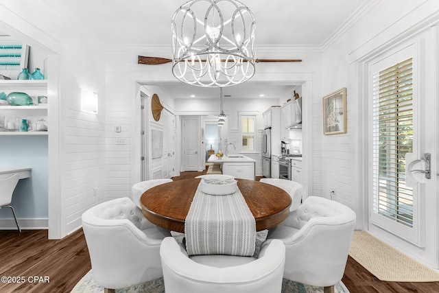 dining room with an inviting chandelier, ornamental molding, and dark wood-style floors