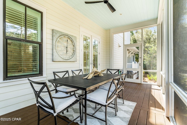 sunroom / solarium featuring a ceiling fan, outdoor dining area, and a healthy amount of sunlight