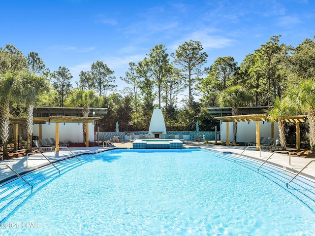 view of swimming pool with a patio and a pool with connected hot tub