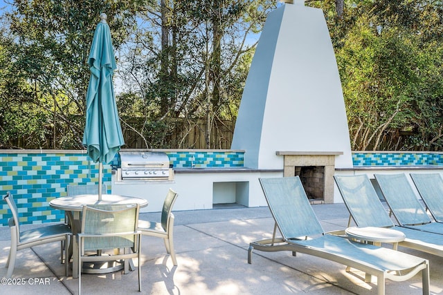 view of patio / terrace with grilling area, an outdoor fireplace, outdoor dining area, and area for grilling