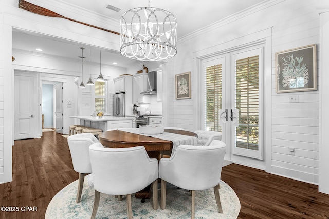 dining space with a notable chandelier, ornamental molding, french doors, and dark wood-style floors