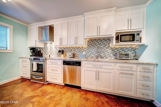 kitchen featuring stainless steel appliances, a sink, wall chimney exhaust hood, white cabinets, and crown molding