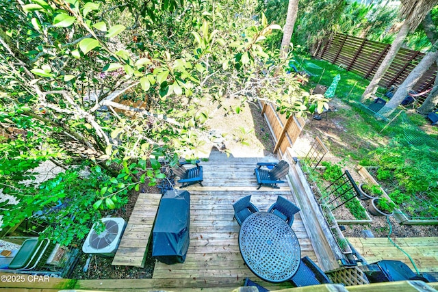 view of patio / terrace with a deck, a garden, and fence