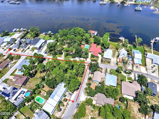 aerial view of property's location featuring a large body of water, property parcel outlined, and nearby suburban area