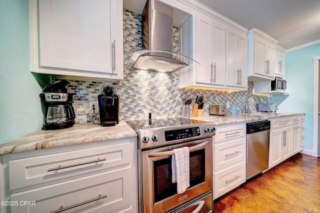 kitchen featuring wall chimney exhaust hood, appliances with stainless steel finishes, a sink, tasteful backsplash, and crown molding