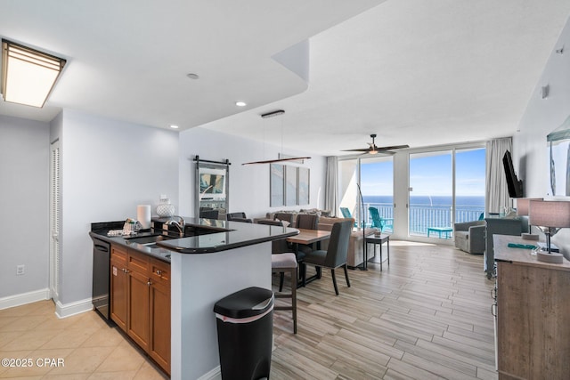 15625 Front Beach Rd Unit 1405, Panama City Beach, FL 32413 - kitchen with a sink, dark countertops, brown cabinetry, and open floor plan