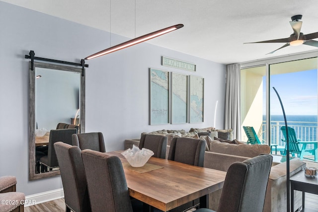 15625 Front Beach Rd Unit 1405, Panama City Beach, FL 32413 - dining space featuring floor to ceiling windows, a ceiling fan, a barn door, and wood finished floors