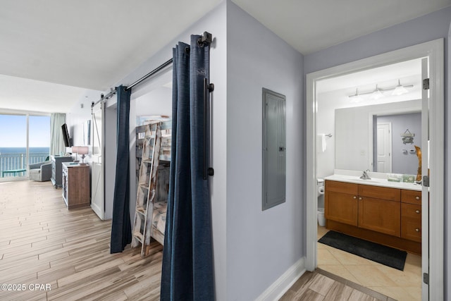 15625 Front Beach Rd Unit 1405, Panama City Beach, FL 32413 - hallway featuring baseboards, a barn door, a sink, and light wood finished floors