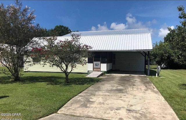 view of front facade with driveway, an attached carport, a front yard, and metal roof