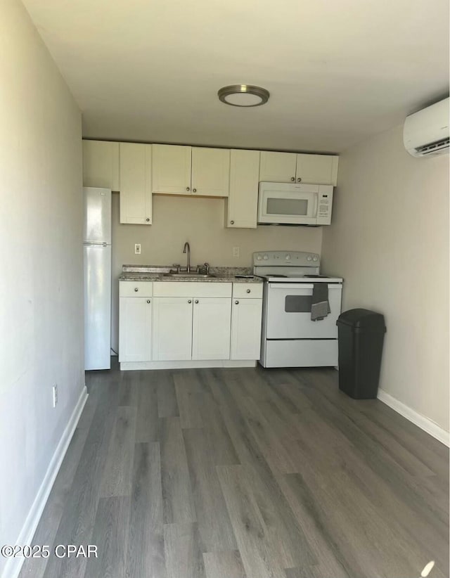 kitchen with baseboards, white cabinetry, and white appliances