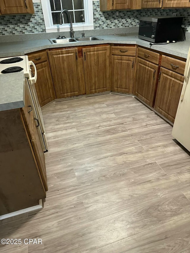 kitchen with black microwave, tasteful backsplash, and a sink