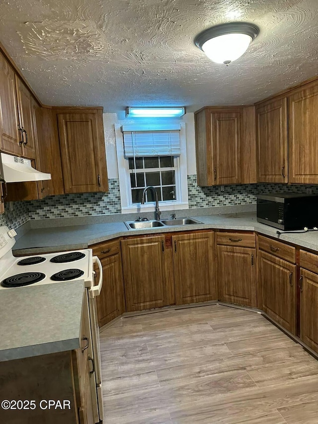 kitchen featuring a sink, decorative backsplash, stainless steel microwave, under cabinet range hood, and white electric stove