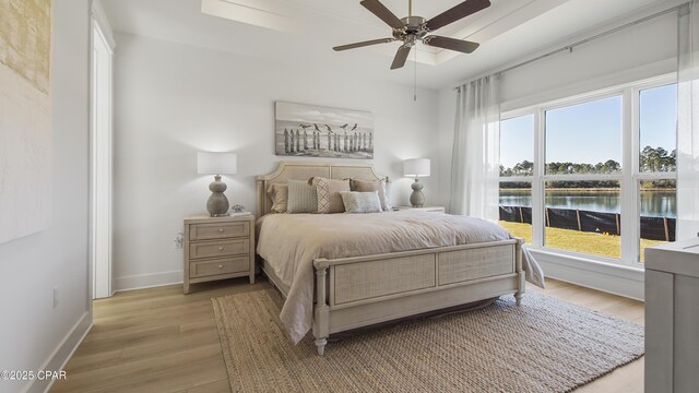 934 Crystal Bayou Blvd, Panama City Beach, FL 32407 - bedroom with light wood-style floors, multiple windows, baseboards, and a water view