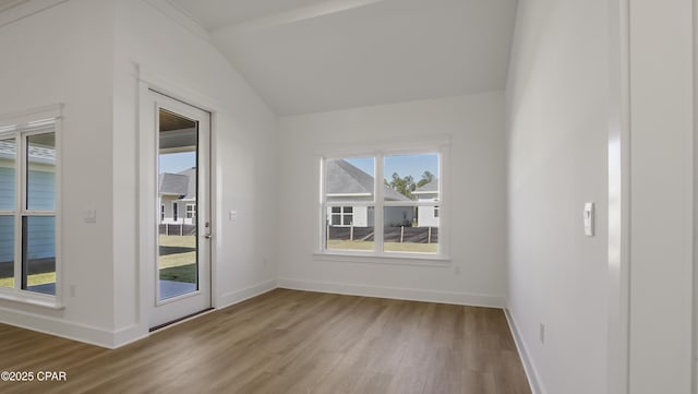 empty room featuring baseboards, light wood-style flooring, and lofted ceiling