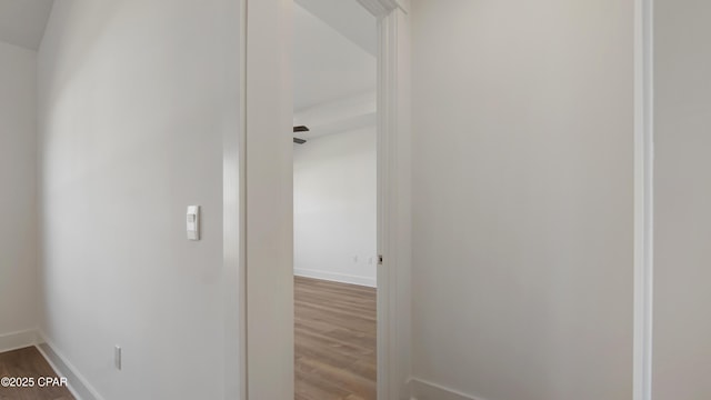corridor with baseboards and wood finished floors