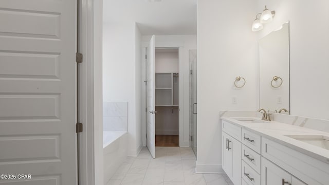full bathroom with a garden tub, a sink, marble finish floor, and double vanity