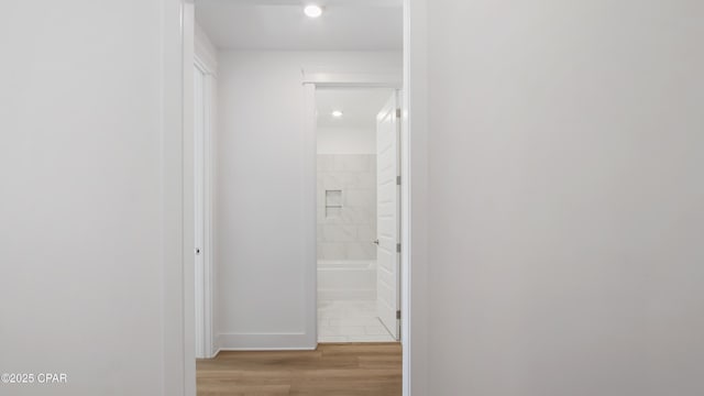 hall featuring light wood-style floors, baseboards, and recessed lighting