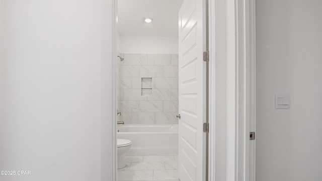 bathroom featuring toilet, shower / bath combination, and marble finish floor
