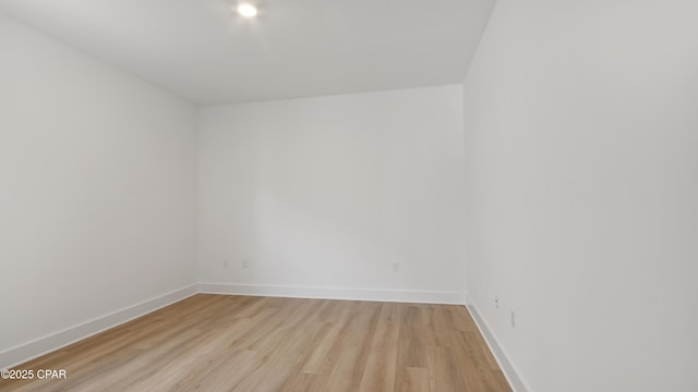 empty room with baseboards and light wood finished floors