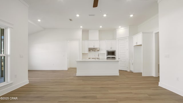 kitchen featuring white cabinetry, under cabinet range hood, a ceiling fan, light wood finished floors, and appliances with stainless steel finishes