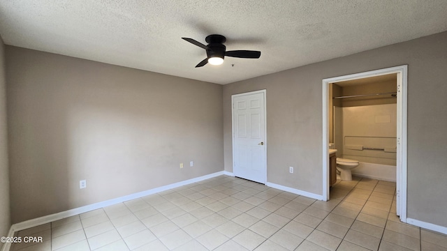 4075 Dancing Cloud Ct Unit 197, Destin, FL 32541 - unfurnished bedroom featuring a textured ceiling, light tile patterned flooring, baseboards, ceiling fan, and connected bathroom