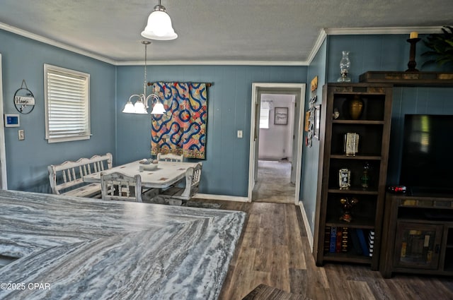 5585 Suncrest Rd, Marianna, FL 32448 - dining area featuring crown molding, wood finished floors, a chandelier, a textured ceiling, and baseboards