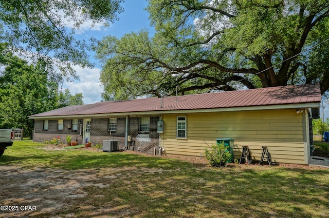 5585 Suncrest Rd, Marianna, FL 32448 - back of house featuring central AC unit, a lawn, and metal roof